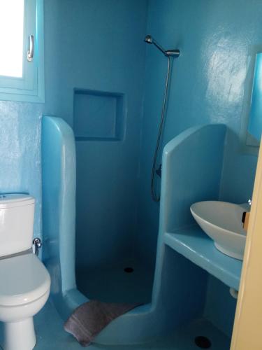 a blue bathroom with a toilet and a sink at Ammos Studio in Koufonisia