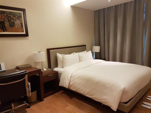 a hotel room with a bed and a desk with a computer at Lotte The Residence in Hanoi