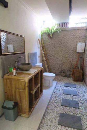 a bathroom with a sink and a toilet at Kerta Family Bed and Breakfast in Ubud