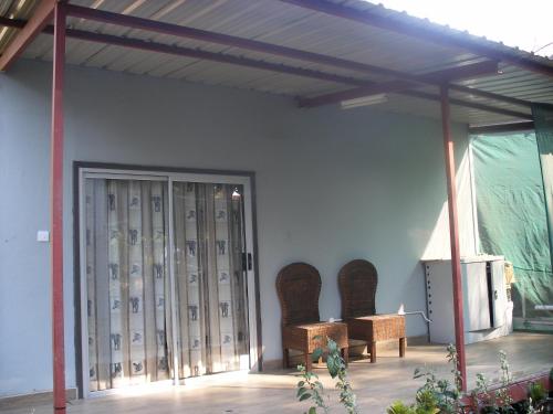 a room with chairs and a wall with a door at Gloria's Bed and Breakfast in Livingstone
