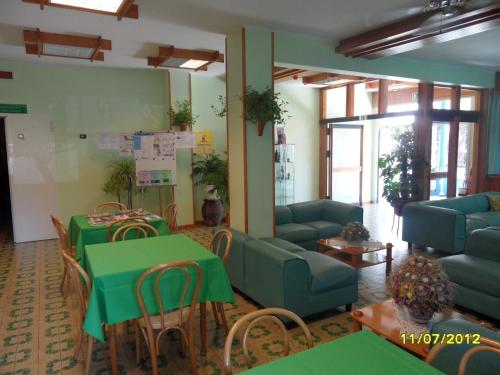 a living room with green tables and couches and chairs at Hotel Prati in Castrocaro Terme