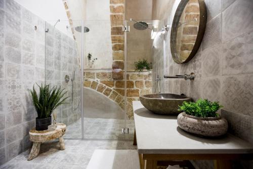 a bathroom with a sink and a glass shower at Akotika boutique in ‘Akko