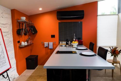 cocina con paredes de color naranja y encimera blanca en Dairyman's Cottage, en Lyndoch