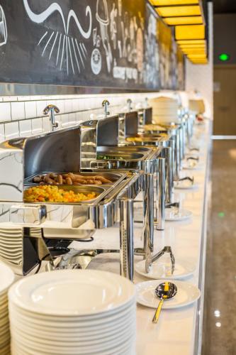 a buffet line with plates of food in a restaurant at ibis Styles Changsha Intl Exhibition Ctr in Huangxing