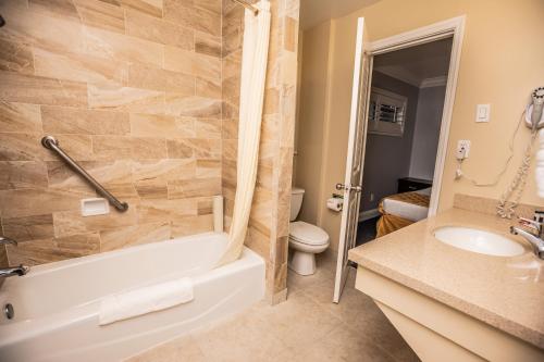 a bathroom with a tub and a sink and a toilet at Aura Inn Monterey in Monterey
