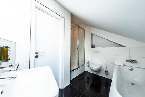 a white bathroom with a sink and a toilet at Mauritius Komfort Hotel in der Altstadt in Cologne