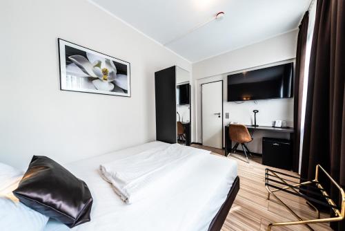 a bedroom with a white bed and a desk at Mauritius Komfort Hotel in der Altstadt in Cologne