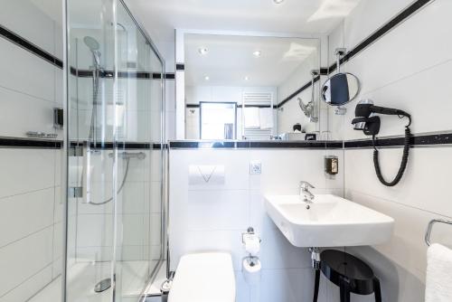 a bathroom with a sink and a shower at Mauritius Komfort Hotel in der Altstadt in Cologne