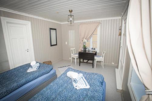 a bedroom with two beds and a table with a piano at Vrangfoss Sluse in Nes