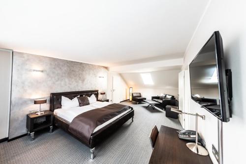 a hotel room with a bed and a flat screen tv at Mauritius Komfort Hotel in der Altstadt in Cologne