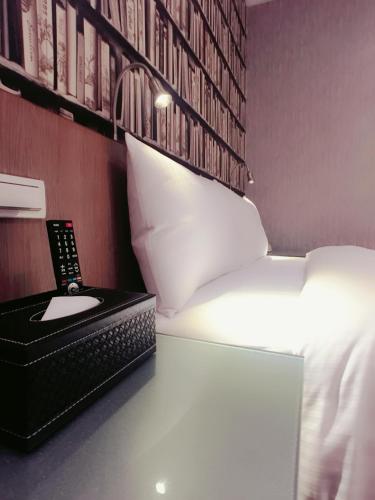 a bed with a desk with a phone and a keyboard at Ueno Hirokoji 428 in Taipei