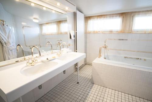 a bathroom with a tub, sink, and mirror at Hotel Seaport in Turku