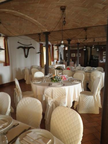 a dining room with white tables and white chairs at Agriturismo Cavazzone in Regnano