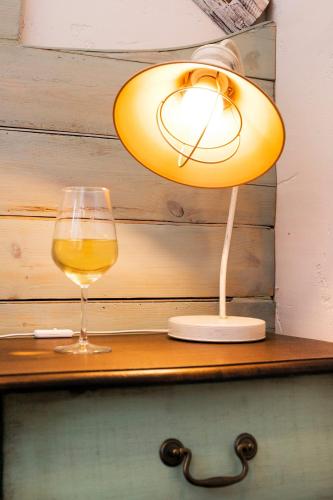 a lamp and a glass of wine on a table at Feniks Agro&Spa Adults Only in Świnoujście