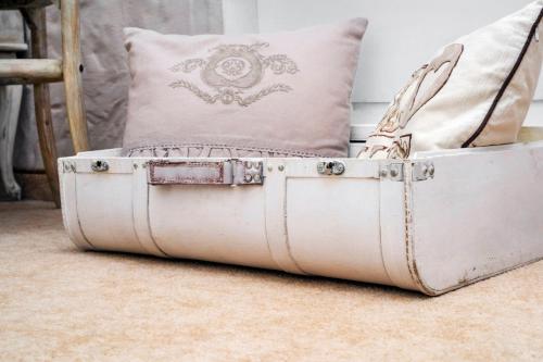 an old suitcase sitting on the floor with a pillow at Feniks Agro&Spa Adults Only in Świnoujście