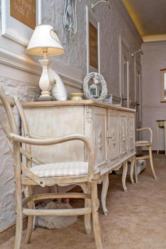 a table with a lamp and a chair in a room at Feniks Agro&Spa Adults Only in Świnoujście