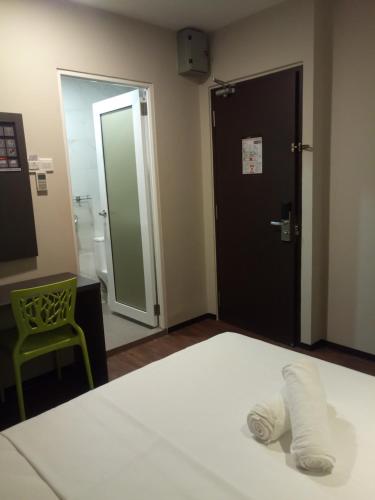 a bedroom with a bed and a bathroom with a mirror at The Loft Plaza Hotel in Bangi