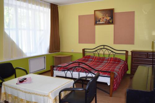 um quarto com uma cama, uma mesa e cadeiras em Apartament Erfolg 12 em Daugavpils