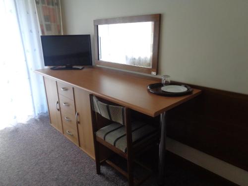 a desk with a television and a computer on it at OW Inter Piast Kalbornia - z własną plażą z kąpieliskiem i przystanią in Dąbrówno