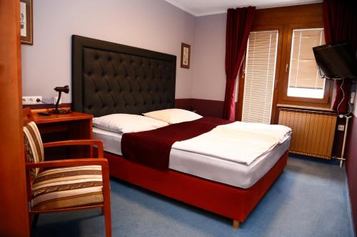 a bedroom with a large bed and a chair at Taverna & Wine Jeruzalem in Ivanjkovci