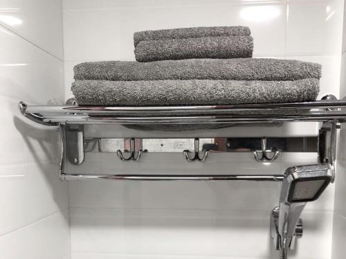 a stack of towels on a metal rack in a bathroom at Hang Fung Hostel in Hong Kong