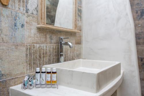 a bathroom sink with bottles of essential oils on a counter at Korali Hotel in Naxos Chora