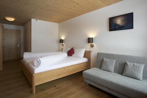 Habitación con cama y sofá. en Hotel Steinbock Vals en Vals