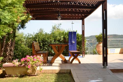 a patio with a table and chairs under a pergola at Villa Rotunda A in Kolymvari