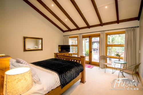 a bedroom with a bed and a table with a television at The Canyons B&B in Queenstown
