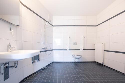 La salle de bains est pourvue d'un lavabo et de toilettes. dans l'établissement Auszeit Das Hotel Himmelkron, à Himmelkron