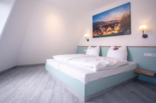 sypialnia z dużym łóżkiem z białą pościelą w obiekcie Auszeit Das Hotel Himmelkron w mieście Himmelkron