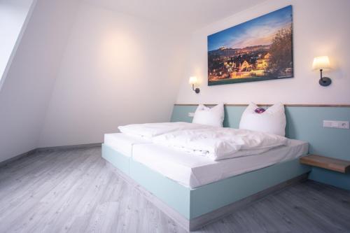 1 dormitorio con 1 cama grande con sábanas blancas en Auszeit Das Hotel Himmelkron, en Himmelkron