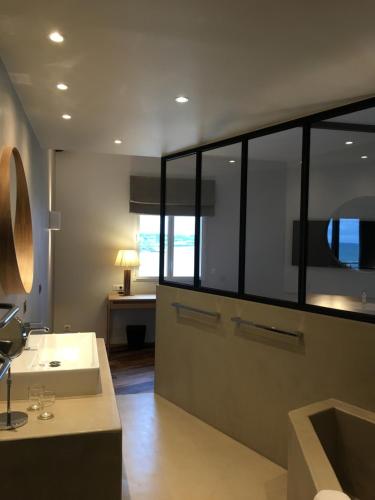 a bathroom with a sink and a large mirror at Hôtel de la Plage - Saint Jean de Luz in Saint-Jean-de-Luz