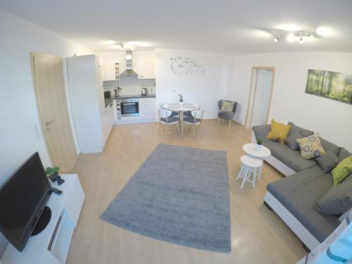 ヘルボルツハイムにあるFerienwohnung Wujanのリビングルーム(ソファ、テレビ付)、キッチン