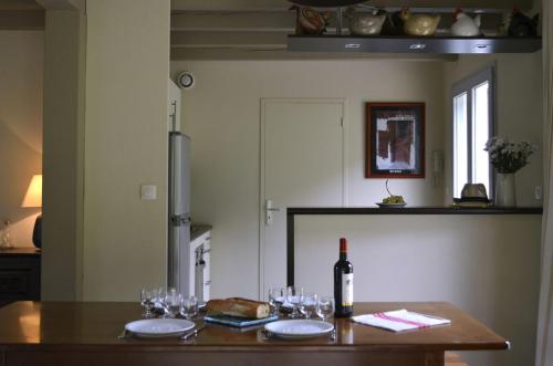 una cocina con una mesa con copas y una botella de vino en Les Villas d'Harri-Xuria, en Saint-Pierre-dʼIrube