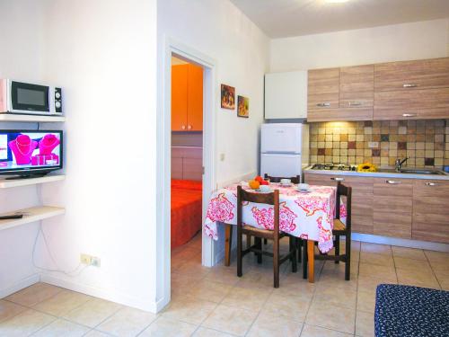 eine Küche und ein Esszimmer mit einem Tisch und Stühlen in der Unterkunft Ivana Belmare apartaments in Bibione