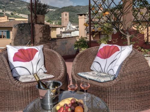 a table with two chairs and wine glasses on a balcony at Hotel Palagi in Pietrasanta