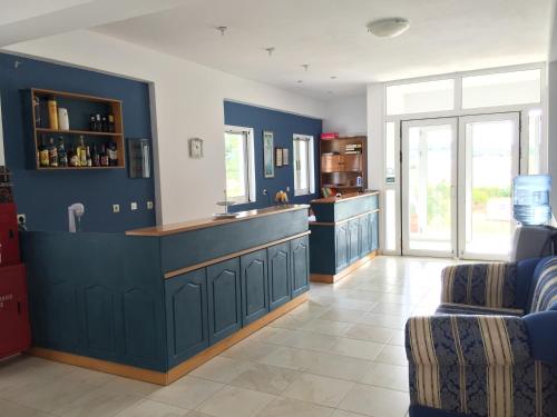 a large kitchen with blue walls and a counter at Kipriotis Hotel in Arkoudi