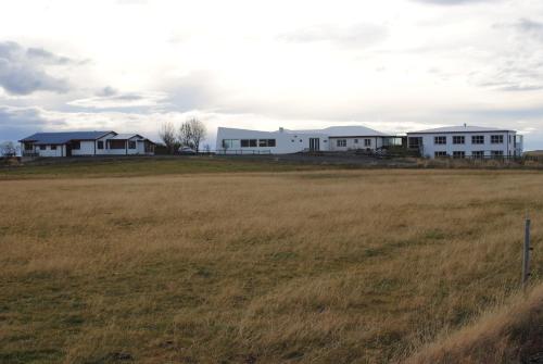 a row of white houses in a field at Brunnholl Country Guesthouse in Höfn