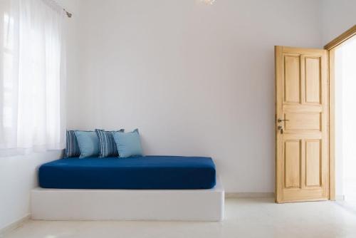 a blue bed sitting in a room with a door at Santorini Crystal Blue Boutique Hotel in Kamari
