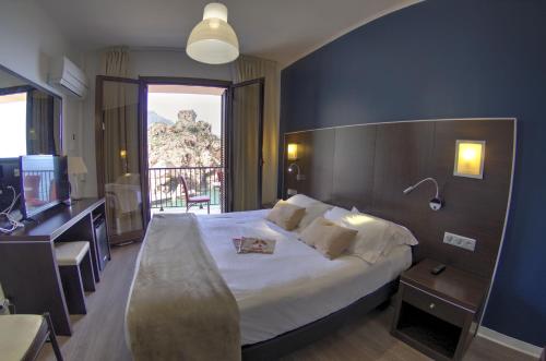 a hotel room with a large bed and a balcony at Les Flots Bleus in Porto Ota