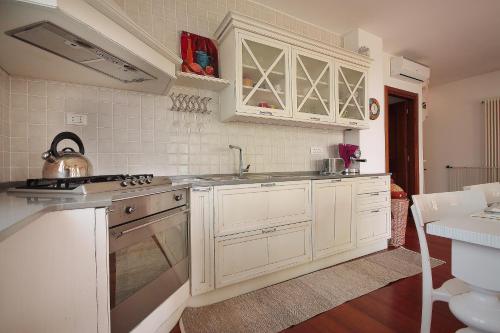 a kitchen with white cabinets and a sink and a stove at Villa Gardoncino in Manerba del Garda