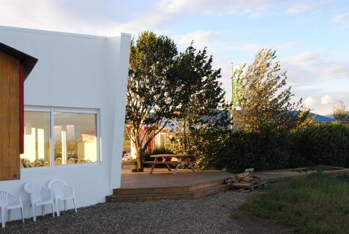 a white house with chairs and a patio at Brunnholl Country Guesthouse in Höfn