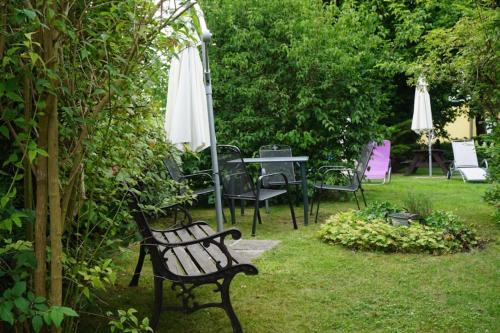 a park bench sitting in the grass with an umbrella at Fischerhus In Krummin - nur für Urlauber in Krummin
