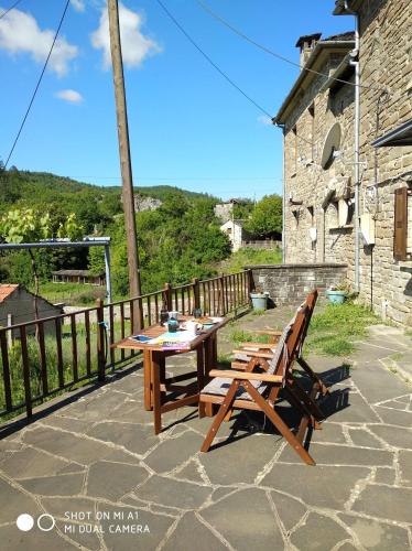 a wooden table and benches on a stone patio at Amanitis Stone House in Kipoi