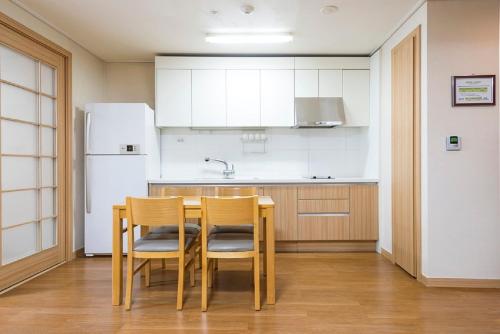 a kitchen with a table and chairs and a refrigerator at Jeongseon Mayhills Resort in Jeongseon