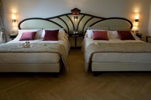 a bedroom with two beds and a lamp at Grand Hotel Savoia in Genova