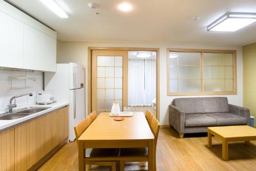 a kitchen with a table and a couch in a room at Jeongseon Mayhills Resort in Jeongseon