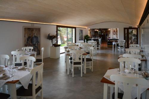 a dining room with white tables and white chairs at Finca Agroturismo Son Menut in Felanitx