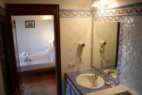 a bathroom with a sink and a mirror and a bed at Finca Agroturismo Son Menut in Felanitx